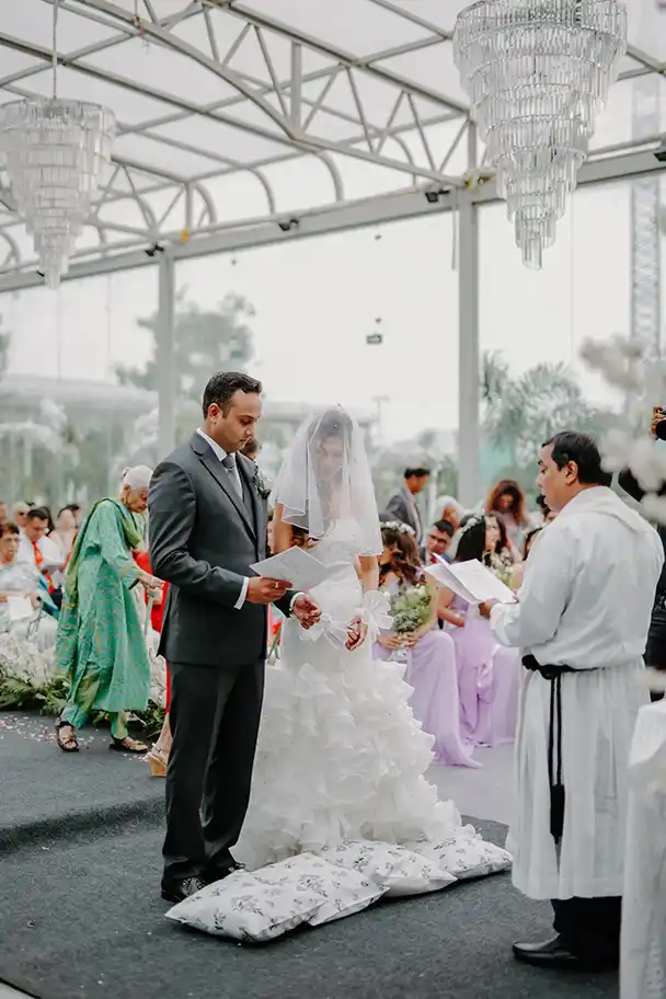 A candid moment of bride Rebecca and groom Akshaan face each other at the altar, reading their personal vows during the ceremony.